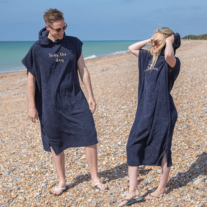 couple wearing personalised changing robes at the beach