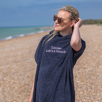 woman in sunglasses wearing personalised changing robe at the beach