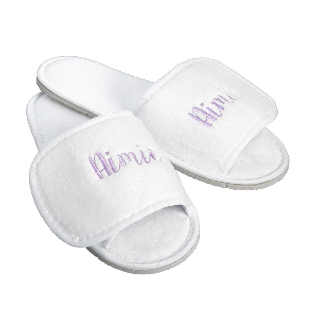 A pair of white plush open-toe slippers with the name 'Aimie' embroidered in lavender script on the straps, shown on a plain white background.