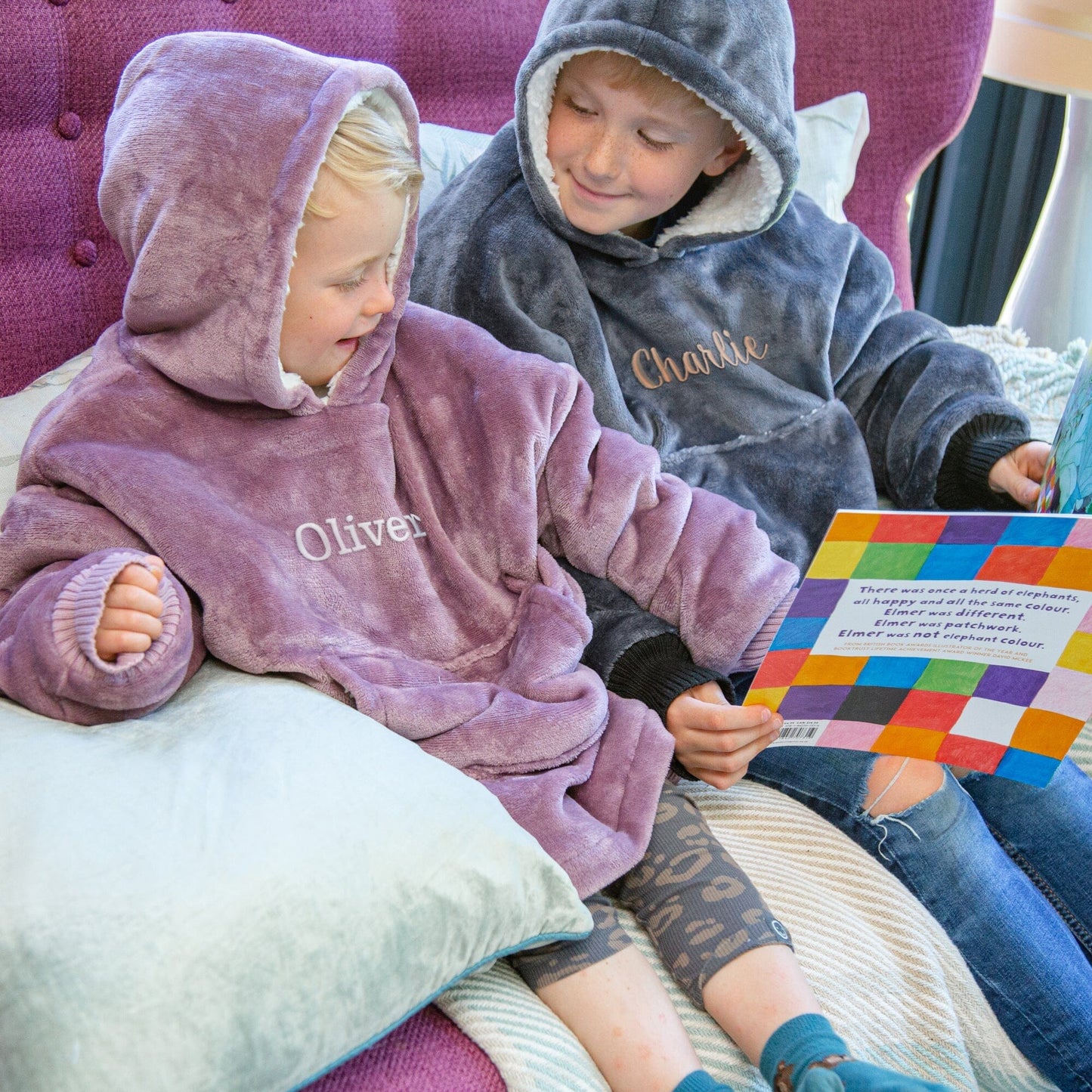 Two kids sitting on a couch wearing Hooded Wearable Blanket