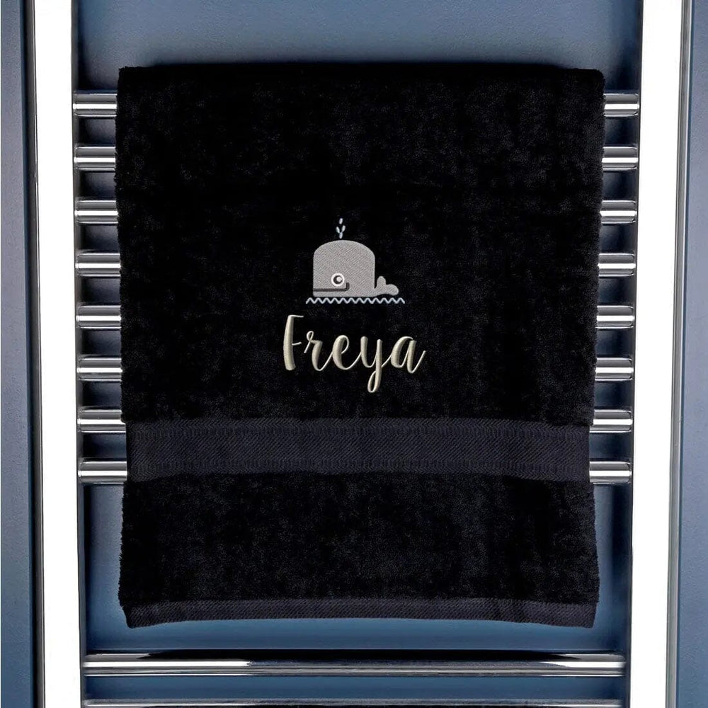 black towel with an embroidered whale and name