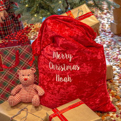 A personalised Christmas Gift Sack next to the tree and gift boxes