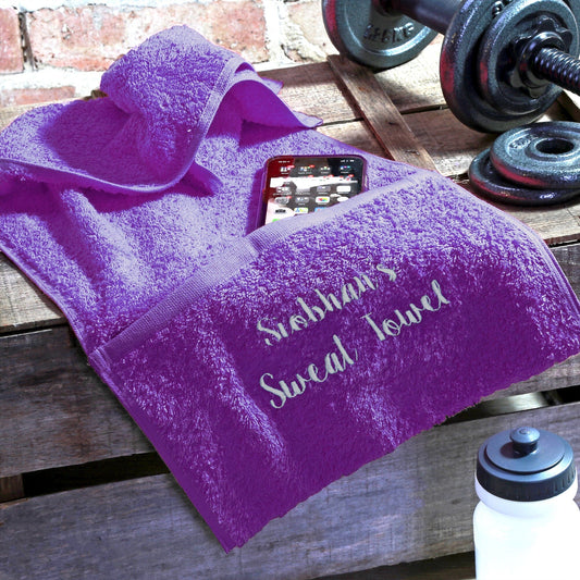 Purple personalsied gym towel with pocket and gym props around