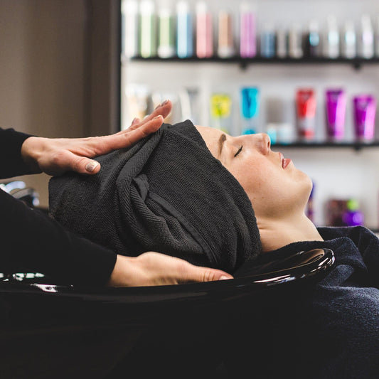 Hair dressing towel wrapped around a female model's head having hair treatment