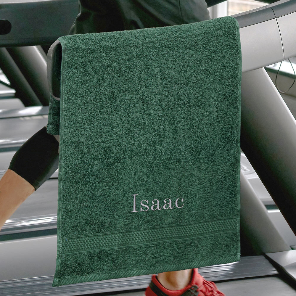 Green personalised gym towel over a treadmil and runner in the backdrop 