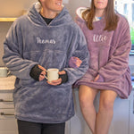 Two people wearing oversized plush sherpa hooded Pooncho in a kitchen setting.
