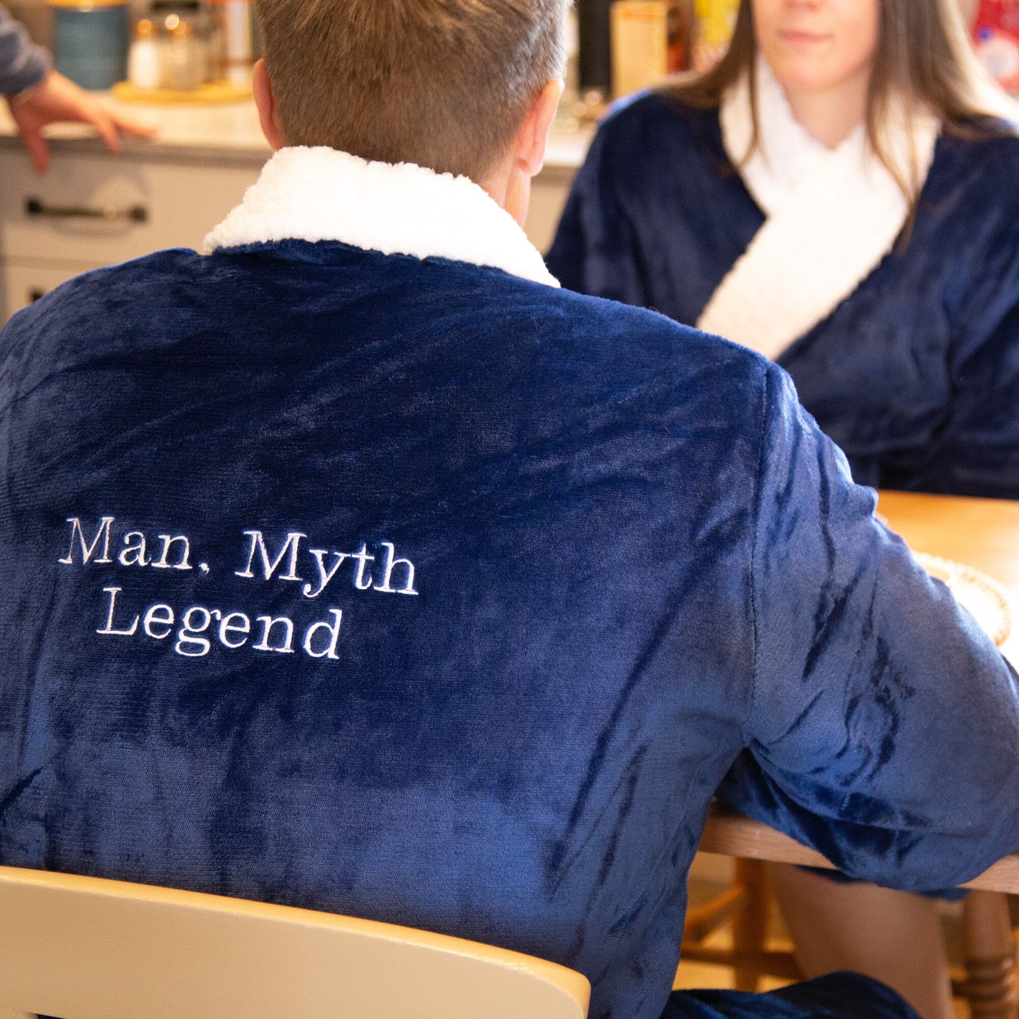 Person wearing a personalised sherpa blue robe with 'Man, Myth Legend' text in a casual setting.