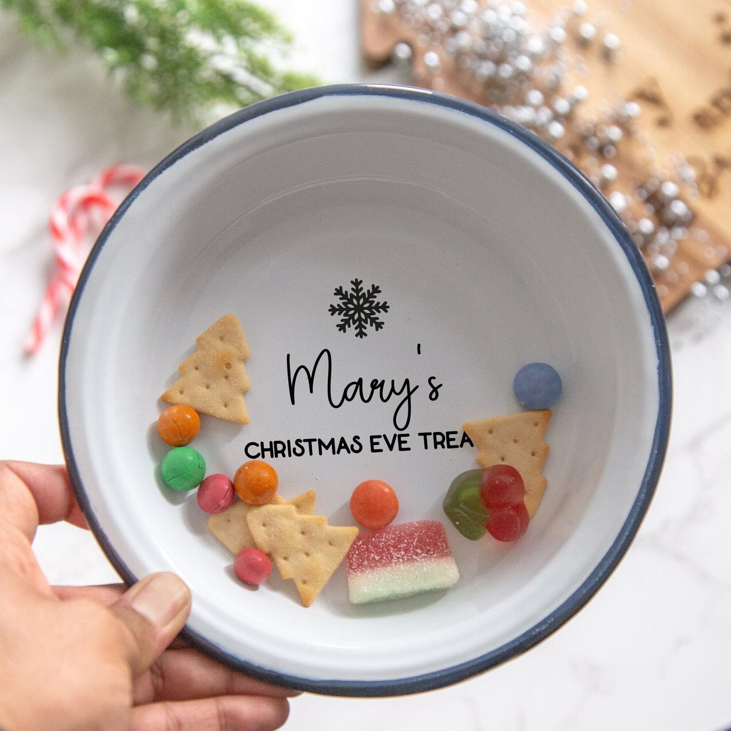 Personalised Christmas Treats Enamel Bowl with christmas treats and christmas props in the backdrop