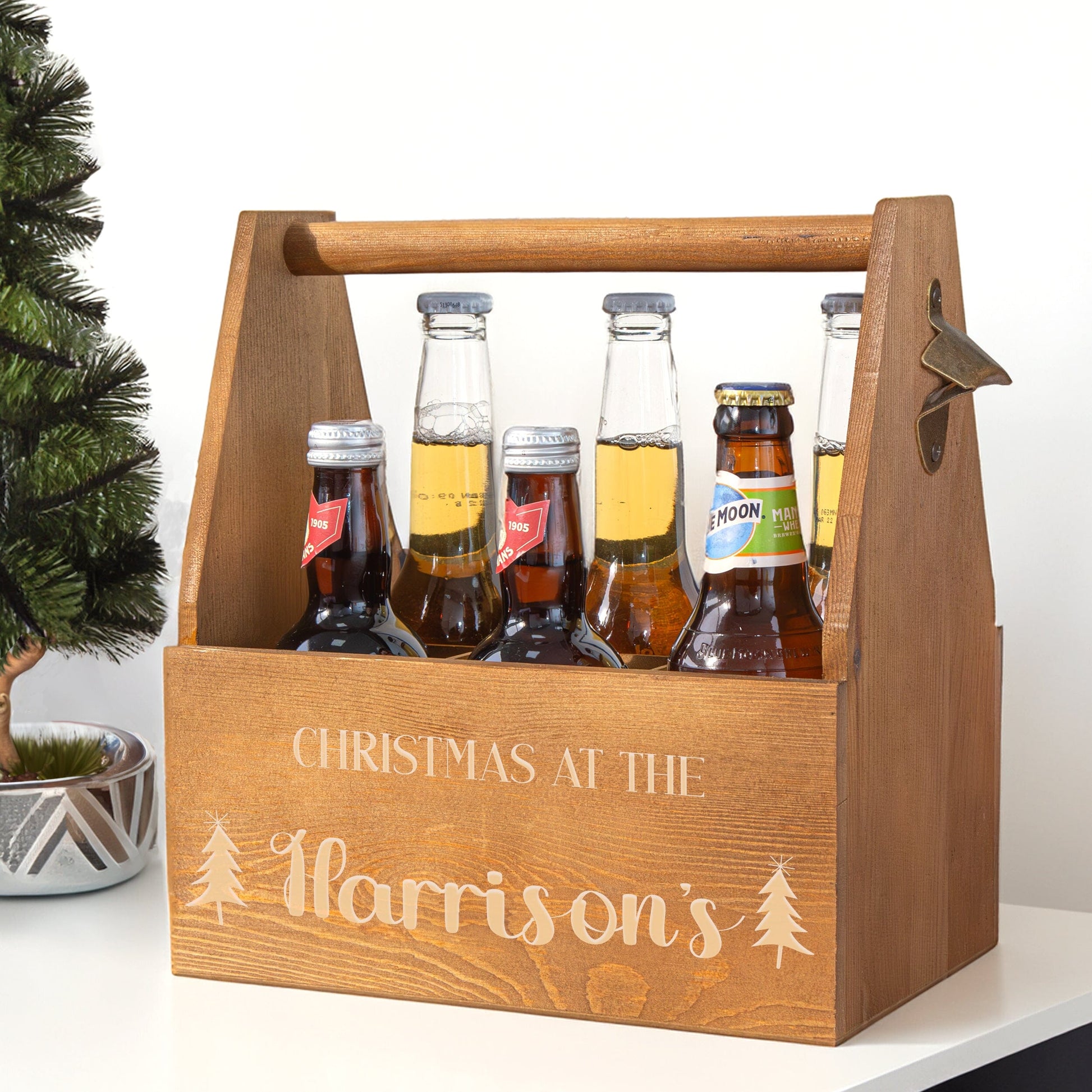 Personalised Christmas Wooden Caddy on a white table with a Christmas tree on one side