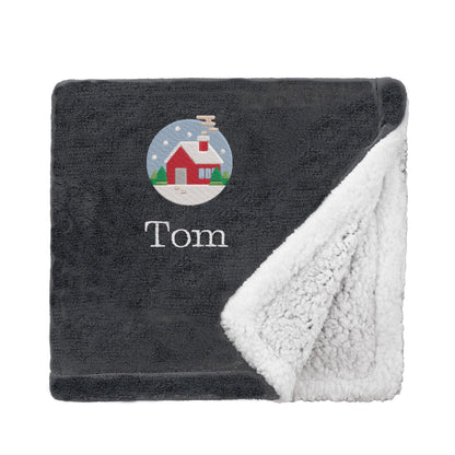 Black Personalised Cosy Christmas Mini Sherpa Blanket With Embroidered Festive Cottage Design On White Backdrop