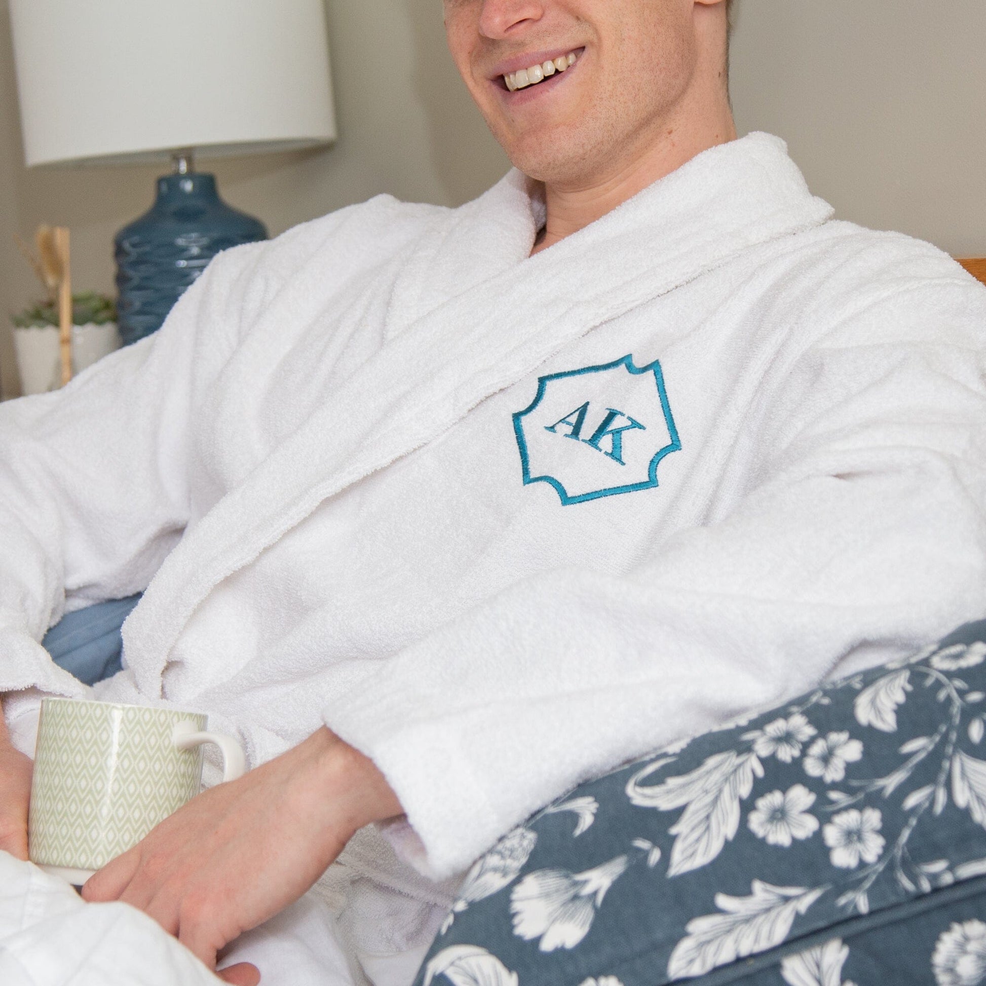 a male sitting wearing a white Personalised Cotton Monogrammed Bathrobe