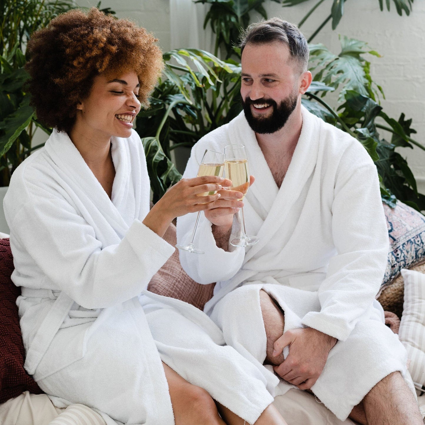 a cheerful couple wearing white Boutique cotton shawl collar bathrobes