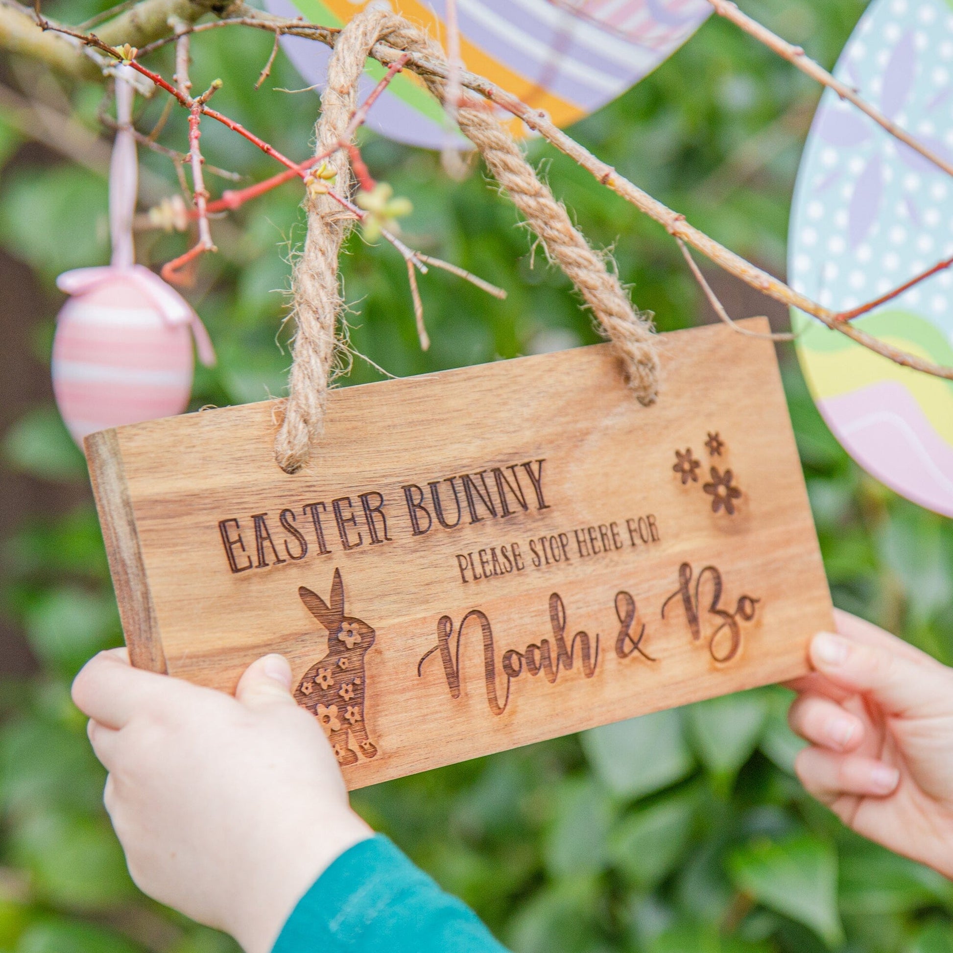 A kid holding the Personalised Easter Bunny Wooden Sign  oudoor