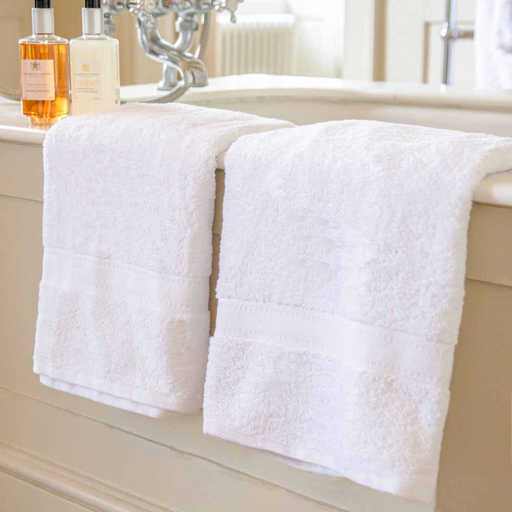 2 bath sheets hanging over bath