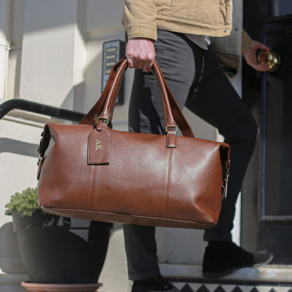 A model holding the Brown Personalised Luggage Tag And PU Leather Holdall Set   