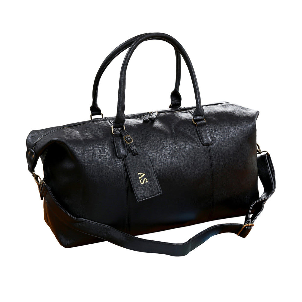 Black Leather Holdall with a debossed luggage tag on white backdrop
