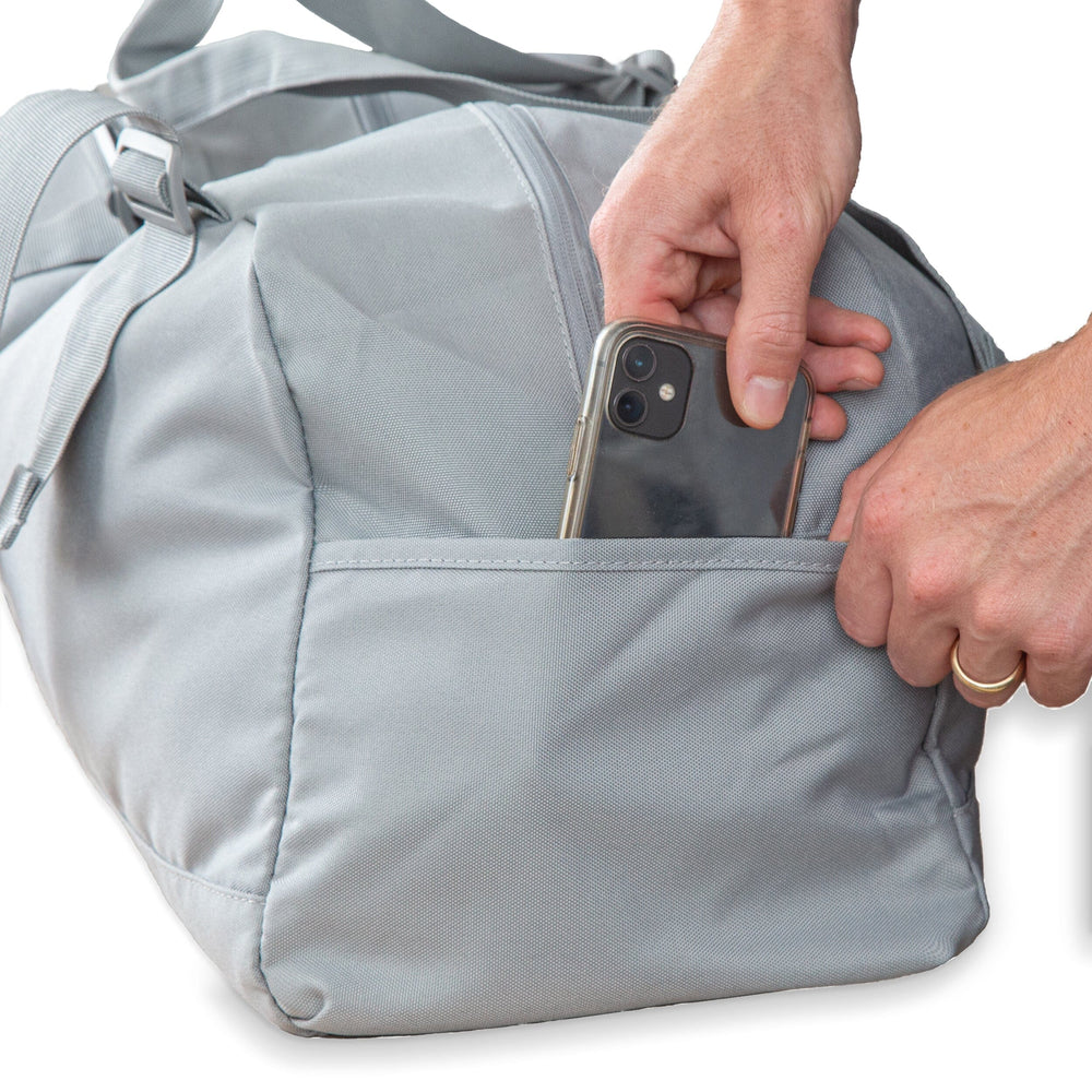 man putting a phone into a bag's outer pocket