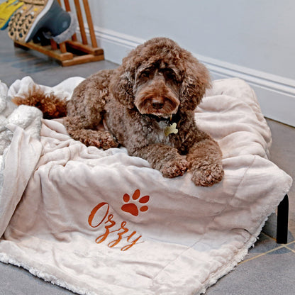 Taupe-coloured Personalised Sherpa Dog blanket with Ozzy embroidered underneath a paw print.