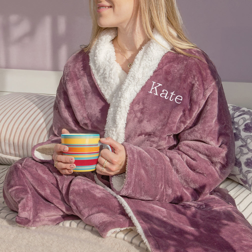 Female wearing a personalised Lavender robe with 'Kate' embroidered on it, holding a colourful mug.