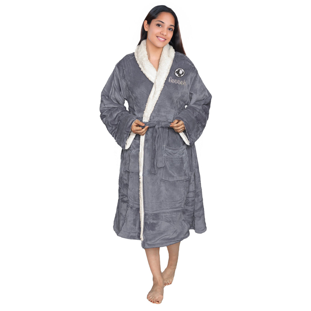 Woman wearing a personalised slate sherpa plush robe with a zodiac Capricorn logo and a personalised, on a white background
