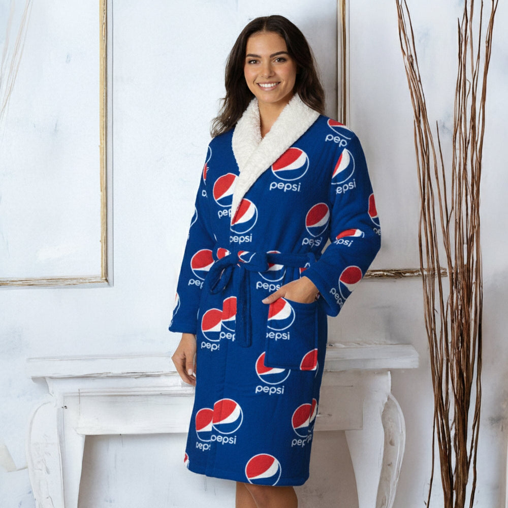 Woman wearing a blue Pepsi robe in a room with white walls and decorative elements.