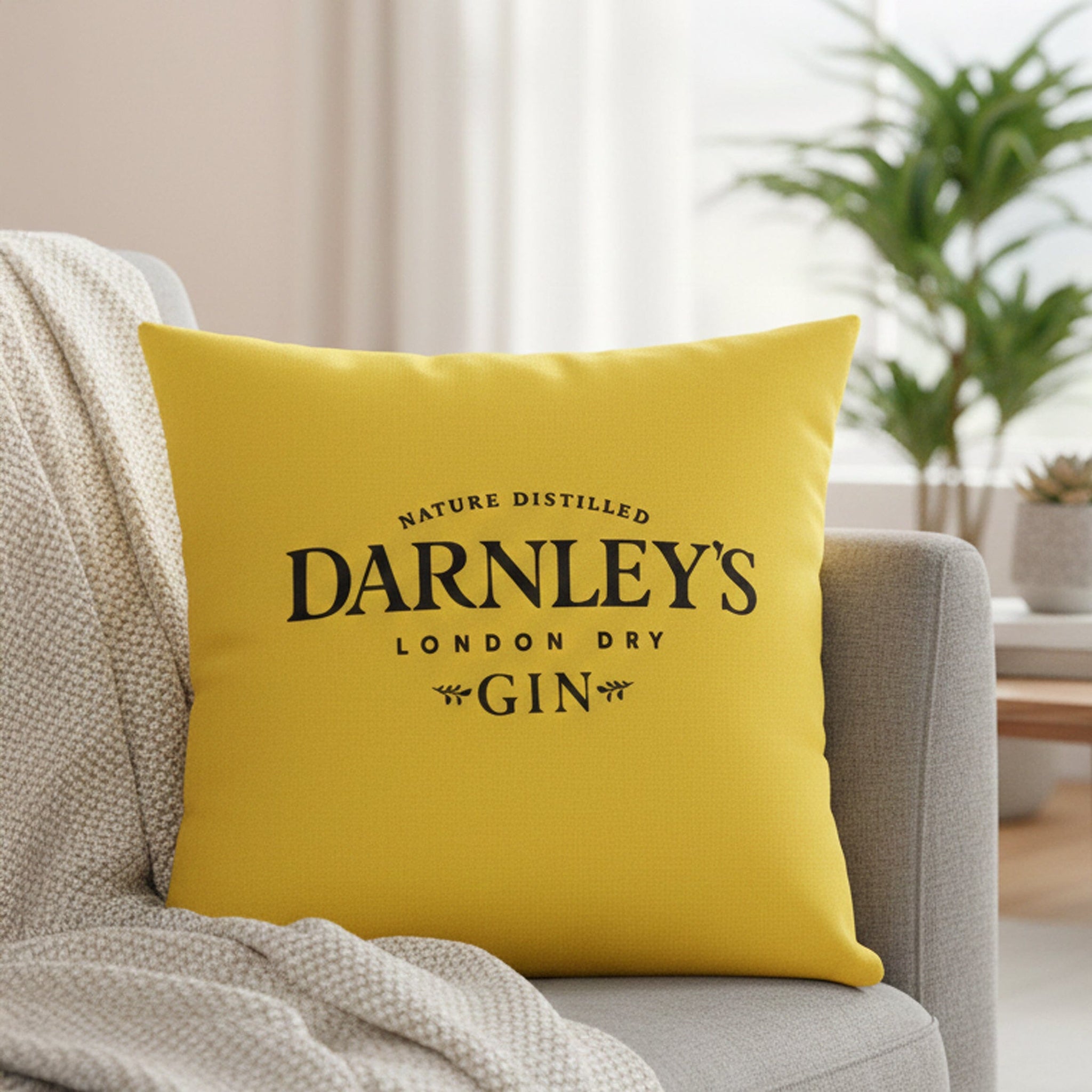 Yellow pillow with 'Darnley's London Dry Gin' text on a couch in a living room setting.