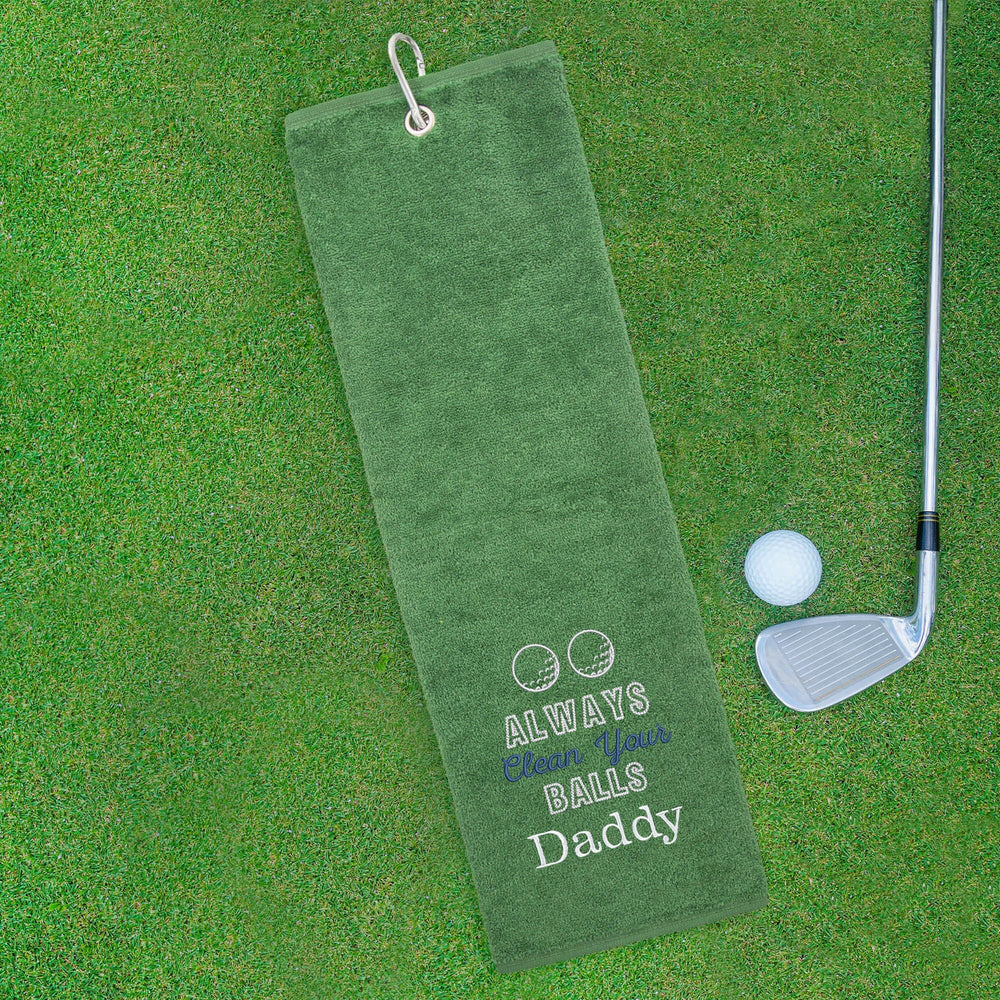 Green golf towel with humorous text on a green grass background