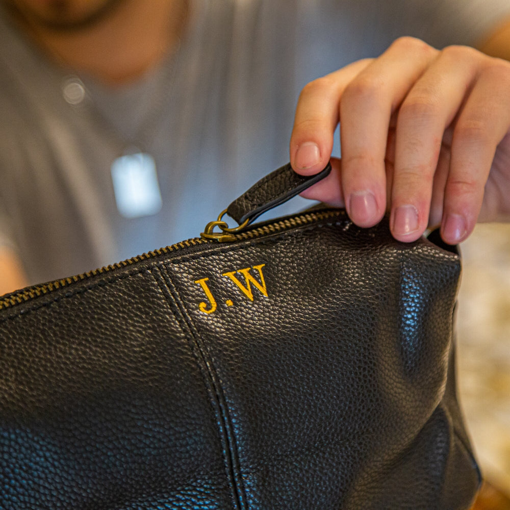 Close up of black wash bag with embroidery