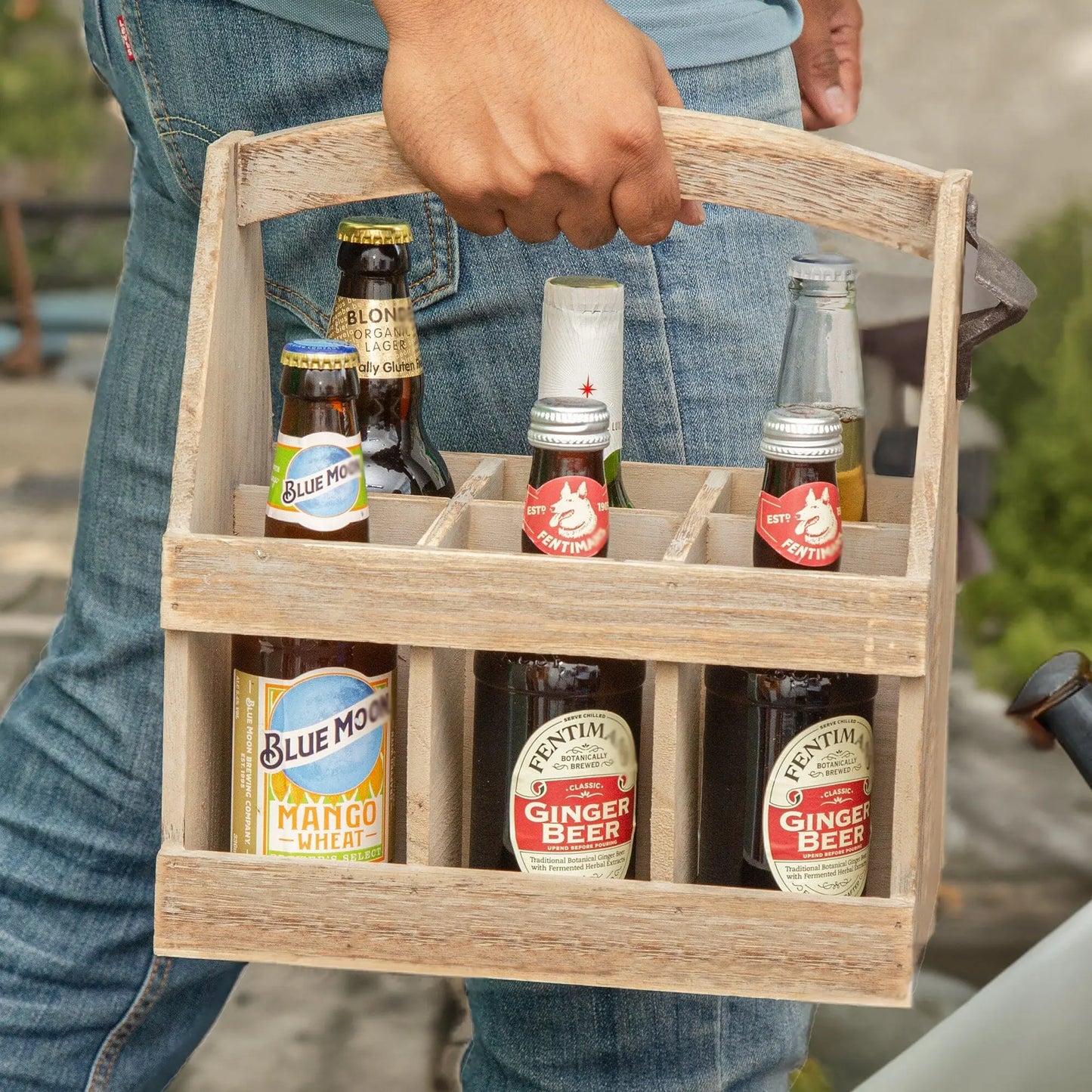 Beer Bottle Caddy with bottled drinks being carried in a garden scene