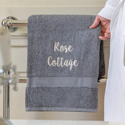 slate grey bath sheet embroidered towel, personalisation reads Rose Cottage in cream coloured text