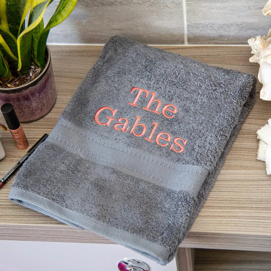 slate grey hand towel with the gables embroidered onto it