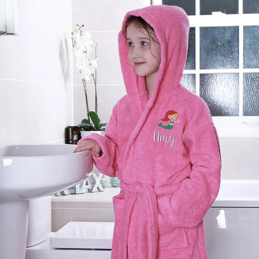 A kid wearing a pink personalised mermaid hooded bathrobe   